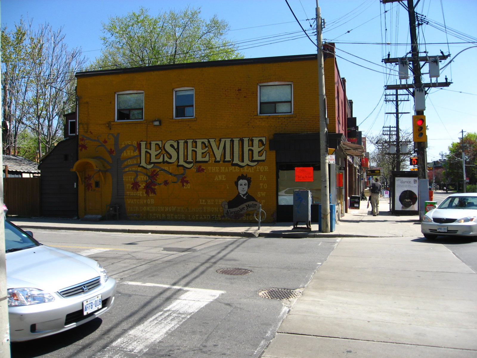 "Welcome to Leslieville" by Linda N. is licensed under CC BY 2.0. Description: Mural with the word "Leslieville" painted on a brick building with cars turning a corner in the foreground.